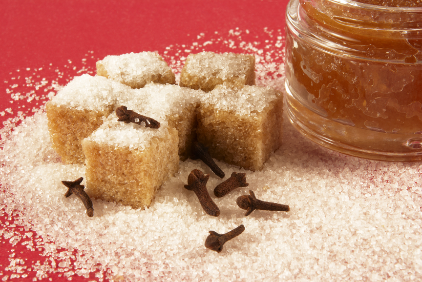 Body scrub with brown sugar crystals, spicinesses, on a red background